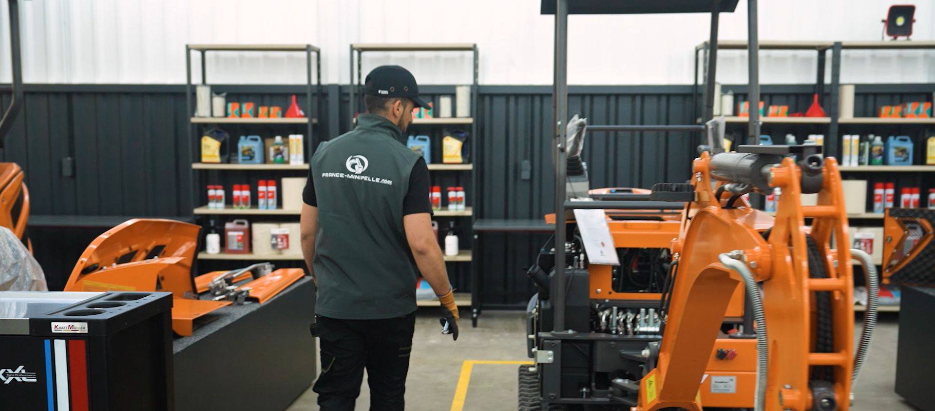 Technicien France Minipelle dans l’atelier, devant une mini-pelle Marshall